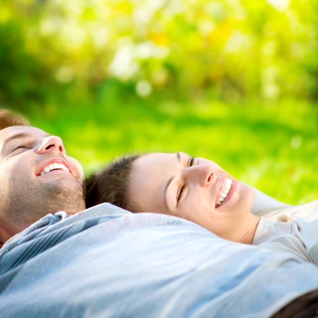 Park. Young Couple Lying on Grass Outdoor